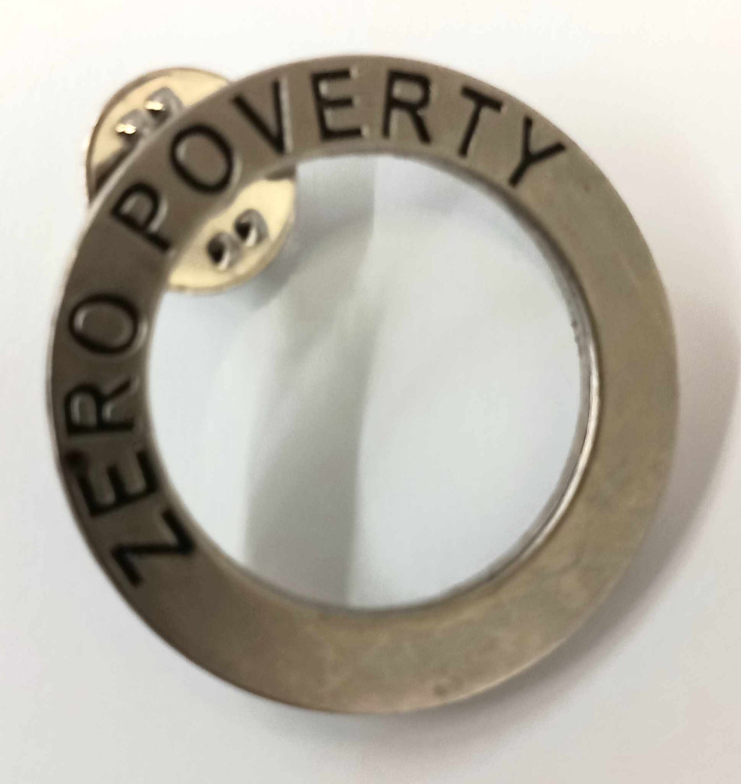 Zero poverty metal circular badge